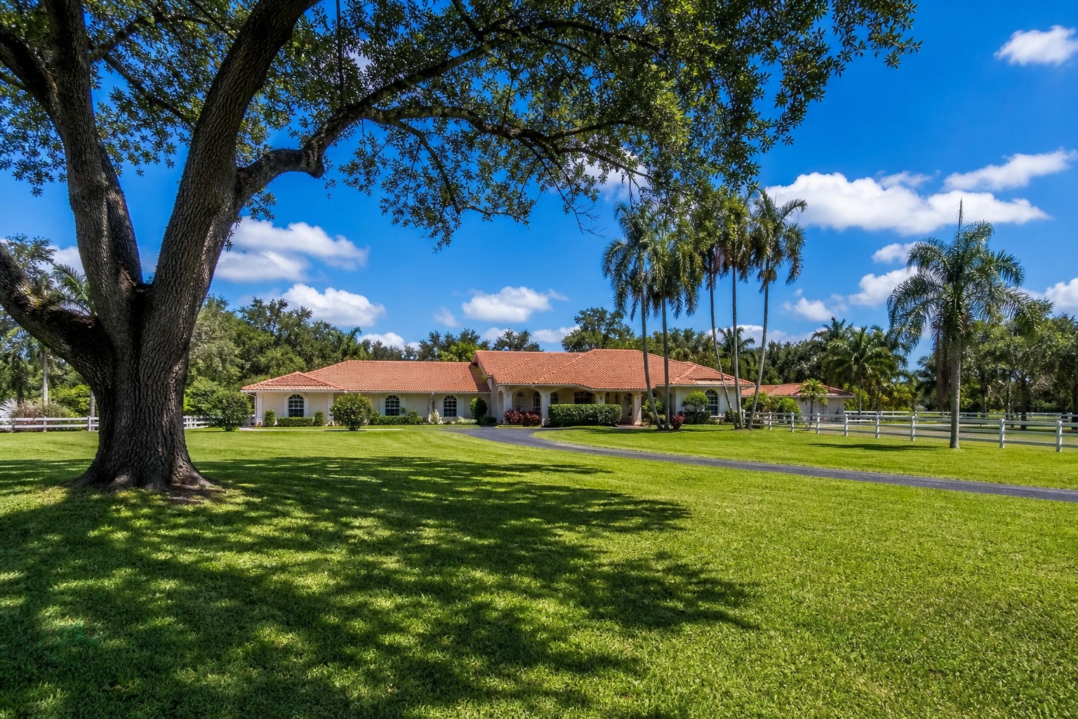 davie florida well water homes buyer guide Single family ranch style home on a large acreage lot with mature oak trees on a sunny day in Davie Florida