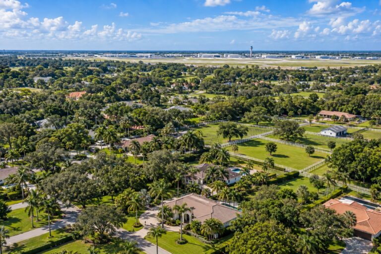 Fort Lauderdale-Hollywood International Airport near Davie Florida with suburban Davie neighborhoods and palm and oak canopy in the foreground relevant to closest airport to Davie FL
